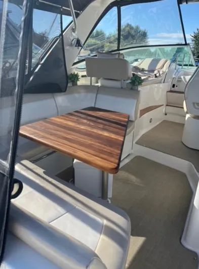  Yacht Photos Pics Interior of 2013 Sea Ray 350 Sundancer with wooden table and seating area.