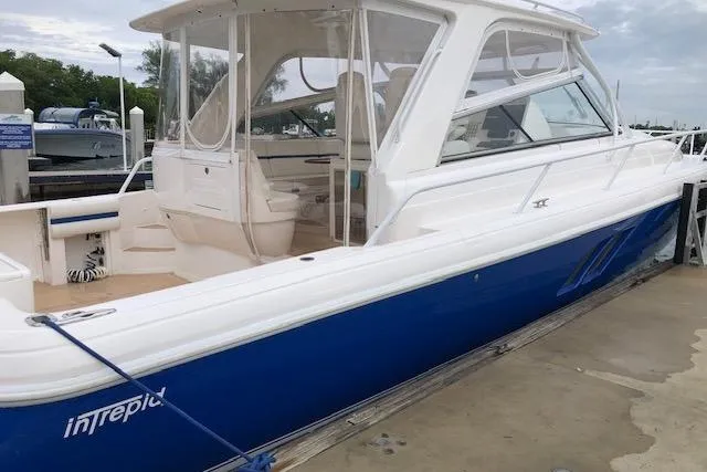  Yacht Photos Pics 2017 Intrepid 475 Sport Yacht with blue hull docked at marina.