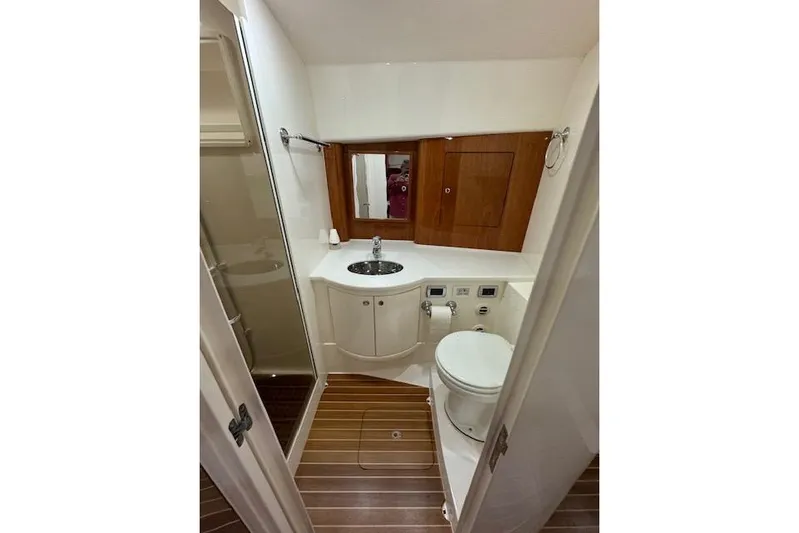  Yacht Photos Pics Bathroom interior of 2017 Intrepid 475 Sport Yacht with wooden accents and modern fixtures.