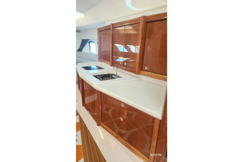  Yacht Photos Pics Luxurious kitchen area in 2017 Intrepid 475 Sport Yacht with wooden cabinetry and modern sink.