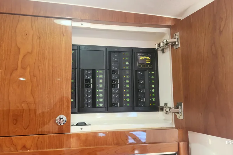  Yacht Photos Pics Electrical panel inside 2017 Intrepid 475 Sport Yacht with wooden cabinet doors open.