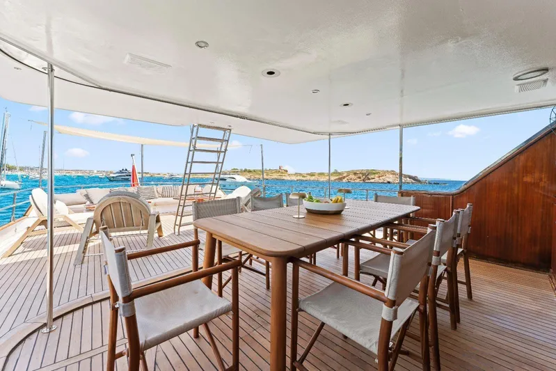 Daylami Yacht Photos Pics Luxurious 1972 Benetti Yachts Classic deck with dining area, overlooking serene ocean views.