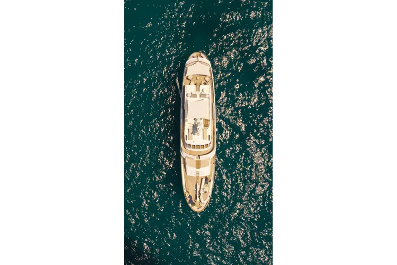Daylami Yacht Photos Pics Aerial view of 1972 Benetti Yachts Classic on sparkling blue water.