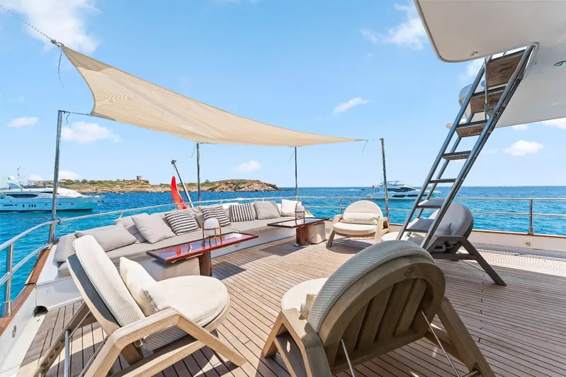 Daylami Yacht Photos Pics Luxurious 1972 Benetti Classic yacht deck with seating, ocean view, and sunshade.