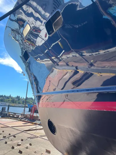 Talos Yacht Photos Pics Shiny hull of 1983 Broward 92 Flushdeck Pilothouse yacht at dockside.