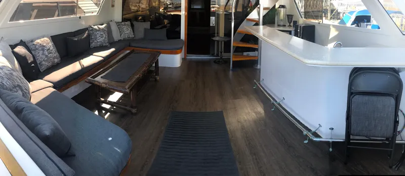 Talos Yacht Photos Pics Luxurious 1983 Broward 92 Flushdeck Pilothouse interior with elegant seating and modern bar area.