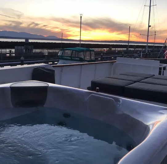 Talos Yacht Photos Pics Hot tub on 1983 Broward 92 Flushdeck Pilothouse yacht at sunset, docked in marina.