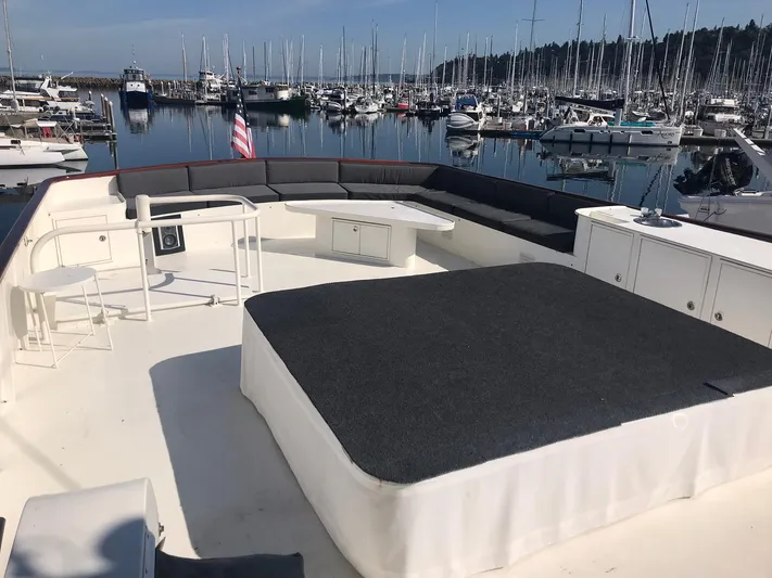Talos Yacht Photos Pics Luxurious 1983 Broward 92 Flushdeck Pilothouse yacht deck with seating, docked in a marina.