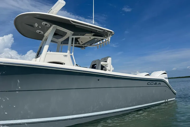  Yacht Photos Pics 2023 Cobia 280 Center Console boat on calm water under clear blue sky.