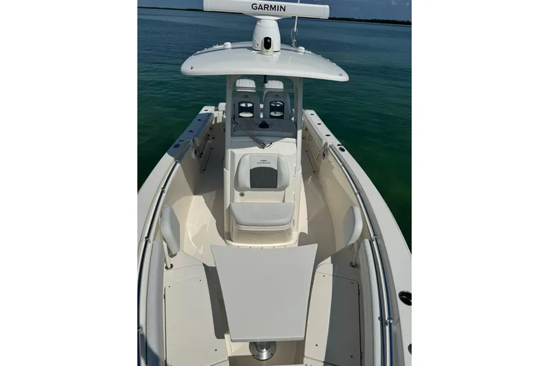  Yacht Photos Pics 2023 Cobia 280 Center Console boat on calm water, featuring a sleek design and modern equipment.