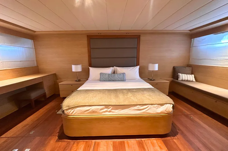 Celebrity Yacht Photos Pics Luxurious bedroom interior on 2001 Ses Yachts custom model, featuring elegant wood finishes.