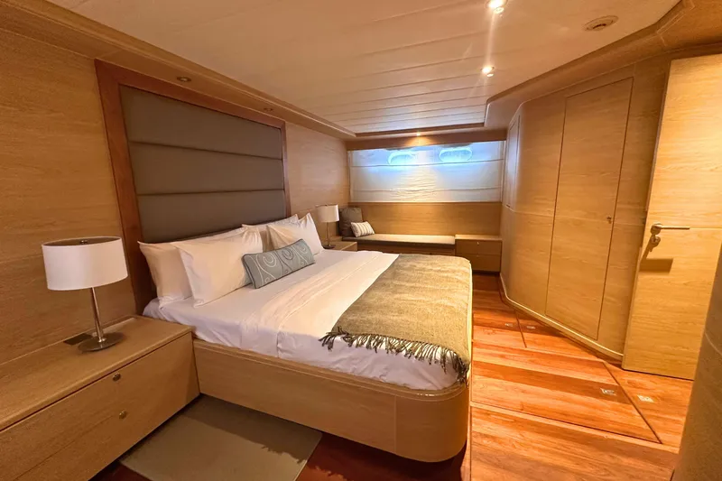 Celebrity Yacht Photos Pics Luxurious bedroom interior of 2001 Ses Yachts custom model, featuring elegant wood finishes.
