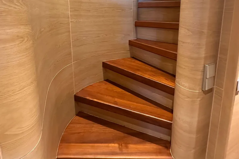 Celebrity Yacht Photos Pics Wooden staircase inside 2001 Ses Yachts custom model, featuring elegant curved design.