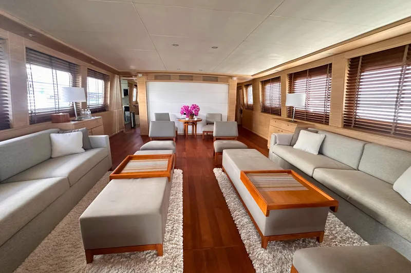 Celebrity Yacht Photos Pics Luxurious yacht interior with elegant seating, wooden accents, and natural light from large windows.