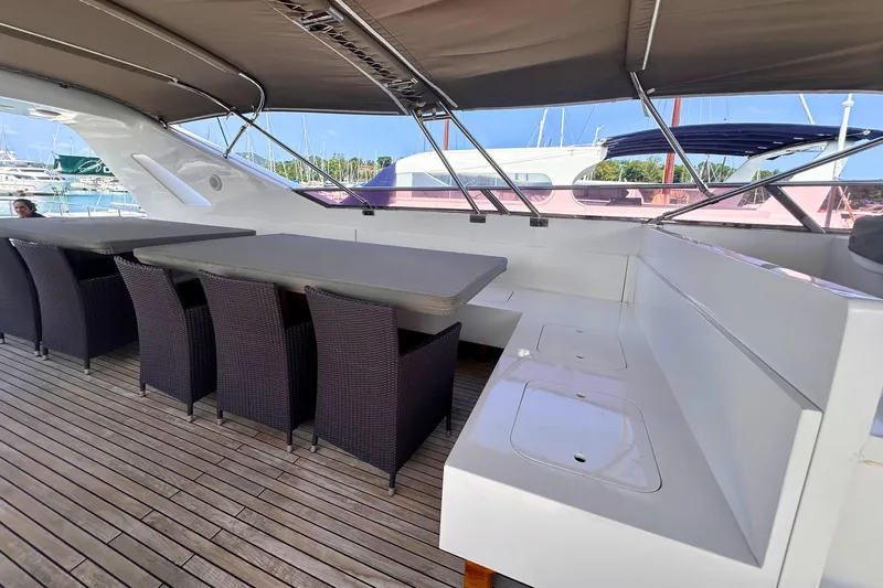 Celebrity Yacht Photos Pics Spacious deck seating on 2001 Ses Yachts custom model, featuring wicker chairs and wooden flooring.