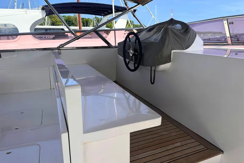 Celebrity Yacht Photos Pics Helm area of 2001 Ses Yachts custom model with covered steering wheel and wooden deck.