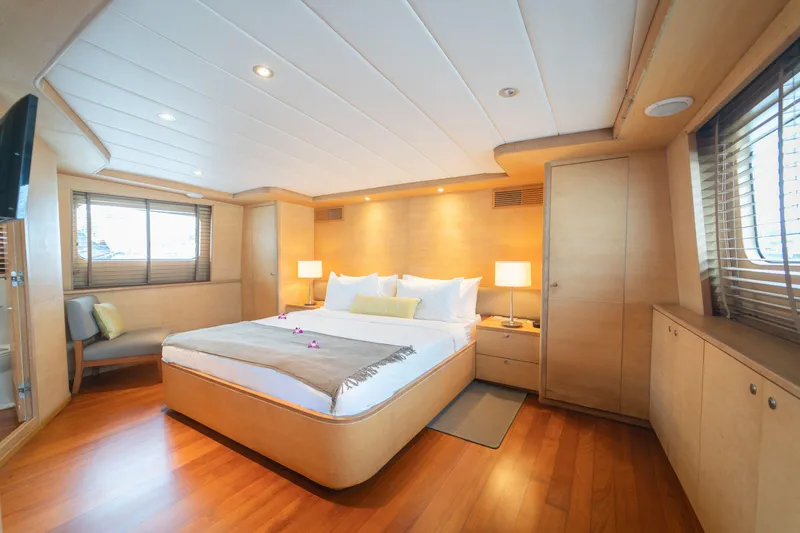 Celebrity Yacht Photos Pics Luxurious yacht bedroom with wooden decor, cozy bed, and soft lighting, Ses Yachts custom 2001.