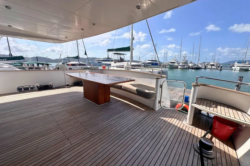 Celebrity Yacht Photos Pics Spacious deck of 2001 Ses Yachts custom model, featuring wooden flooring and marina view.