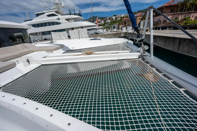 Starry Night Yacht Photos Pics 2022 Lagoon 46 catamaran docked, featuring spacious netted deck area.
