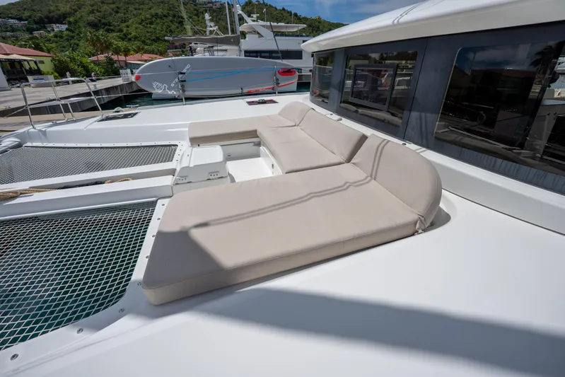 Starry Night Yacht Photos Pics 2022 Lagoon 46 catamaran with beige deck seating and netting, docked in a marina.
