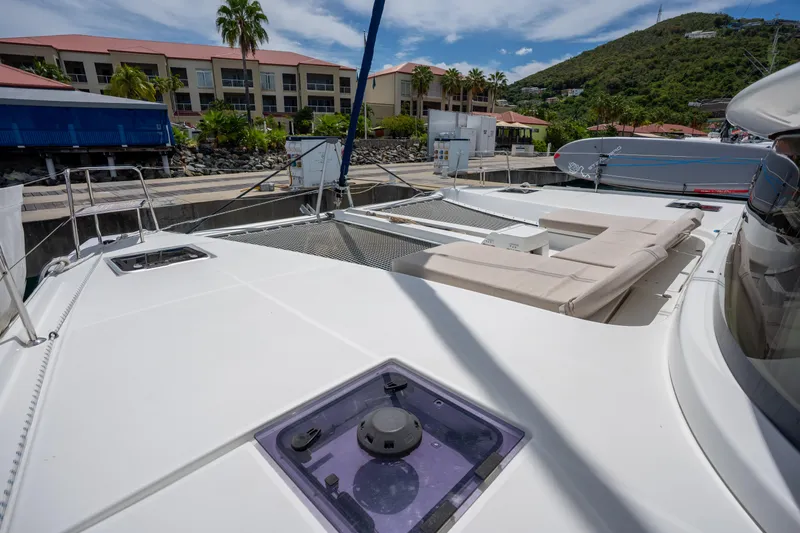 Starry Night Yacht Photos Pics 2022 Lagoon 46 catamaran deck with seating, docked near tropical resort.