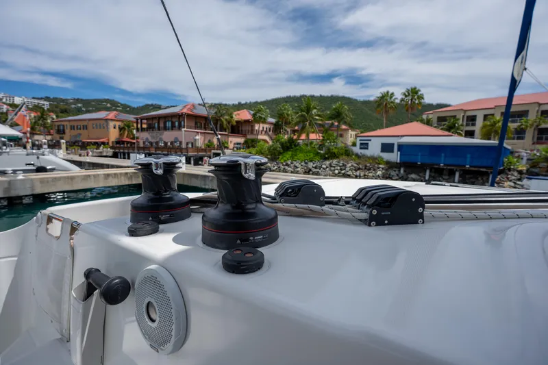 Starry Night Yacht Photos Pics 2022 Lagoon 46 yacht deck with winches, docked near tropical buildings.