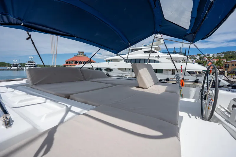 Starry Night Yacht Photos Pics Luxurious 2022 Lagoon 46 yacht with spacious deck and comfortable seating under a blue canopy.