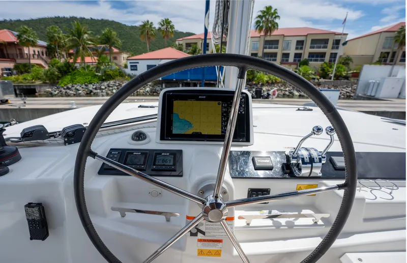 Starry Night Yacht Photos Pics Steering wheel and navigation system of 2022 Lagoon 46 catamaran at marina.