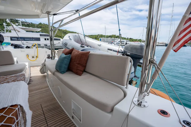 Starry Night Yacht Photos Pics Luxurious 2022 Lagoon 46 yacht deck with comfortable seating and scenic marina view.