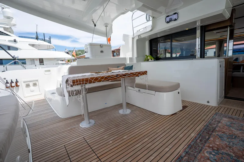 Starry Night Yacht Photos Pics Luxurious 2022 Lagoon 46 yacht deck with seating and elegant wood flooring.