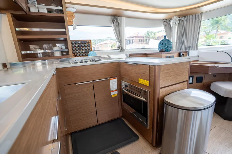 Starry Night Yacht Photos Pics Modern kitchen interior of 2022 Lagoon 46 yacht with wood cabinetry and stainless steel appliances.