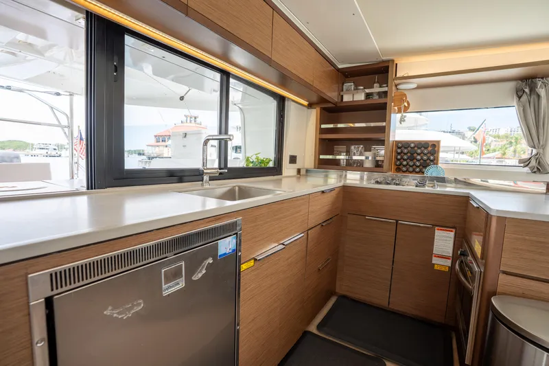 Starry Night Yacht Photos Pics Modern kitchen interior of 2022 Lagoon 46 yacht with sleek wood cabinetry and stainless steel appliances.