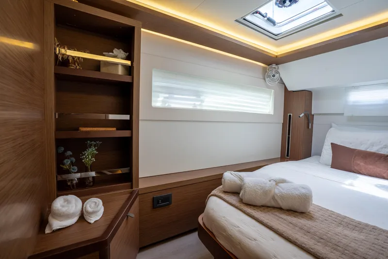 Starry Night Yacht Photos Pics Luxurious cabin interior of 2022 Lagoon 46 yacht with elegant wood finishes and cozy bedding.