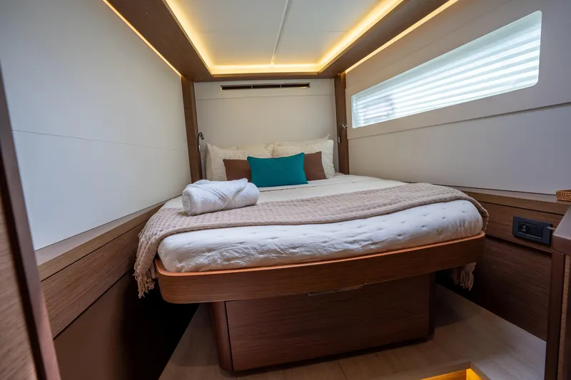 Starry Night Yacht Photos Pics Luxurious cabin interior of 2022 Lagoon 46 yacht with cozy bedding and ambient lighting.