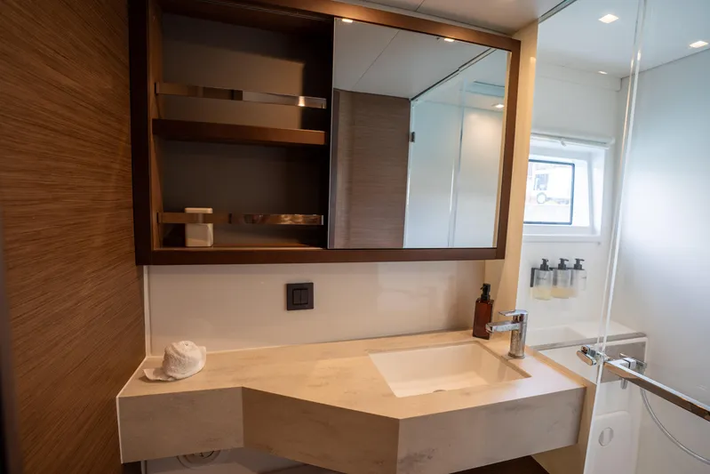 Starry Night Yacht Photos Pics Modern bathroom in 2022 Lagoon 46 yacht with sleek sink and wooden shelving.
