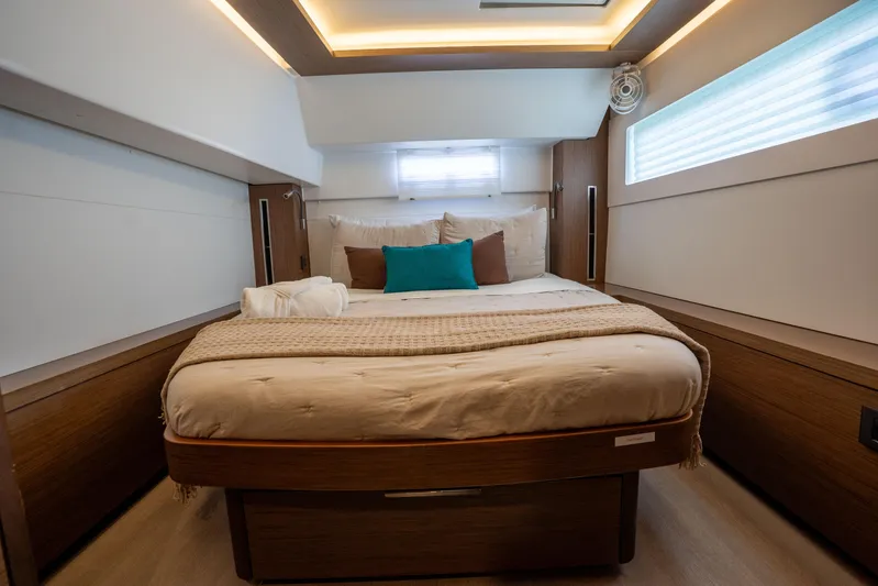 Starry Night Yacht Photos Pics Luxurious bedroom interior of 2022 Lagoon 46 yacht with modern design and cozy bedding.