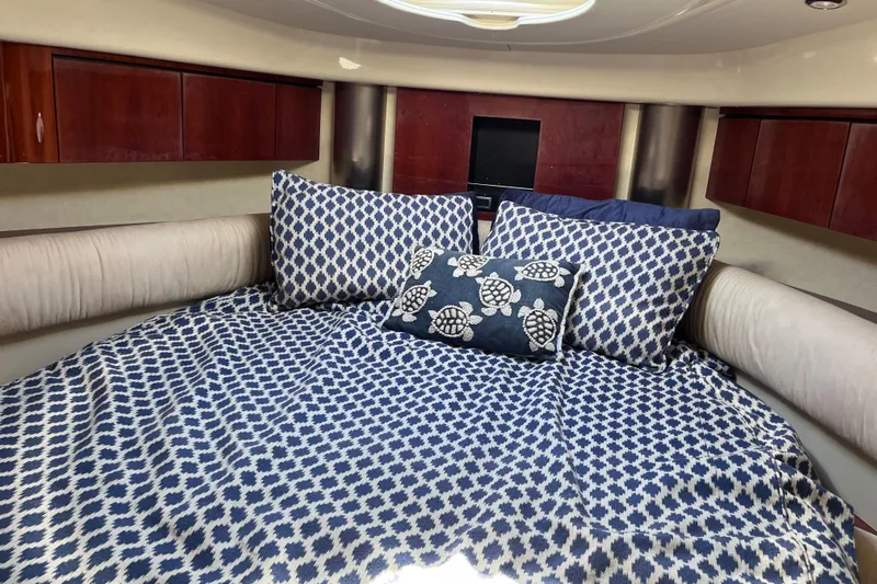  Yacht Photos Pics Cozy cabin interior of 2006 Fairline Targa 40 with patterned bedding and wooden cabinets.