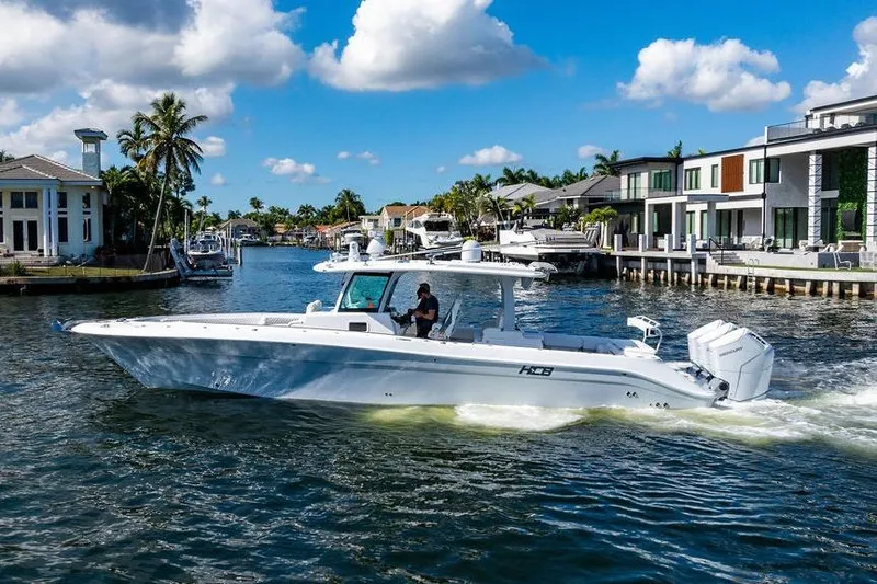  Yacht Photos Pics 2024 HCB 42 Lujo boat cruising in a scenic waterfront neighborhood.