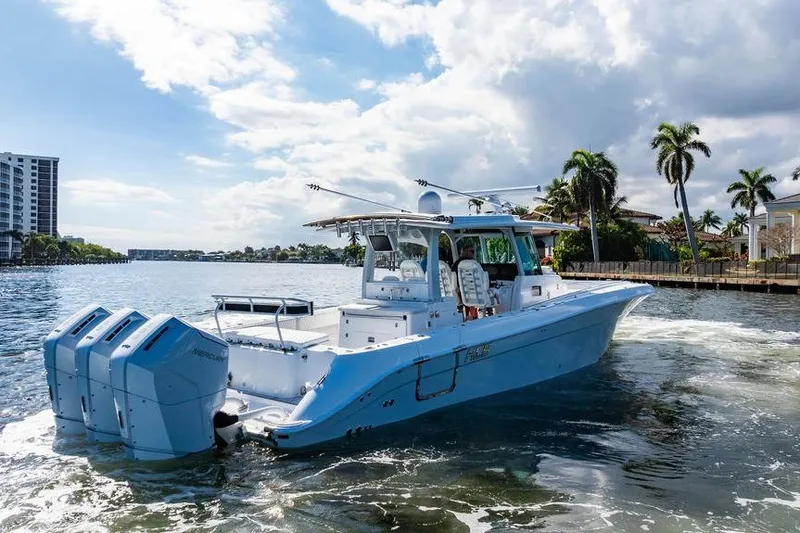  Yacht Photos Pics 2024 HCB 42 Lujo boat cruising on a sunny waterway with palm trees.