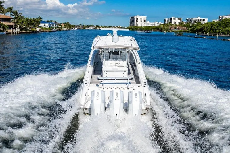  Yacht Photos Pics 2024 HCB 42 Lujo boat cruising on a scenic waterway with city skyline.