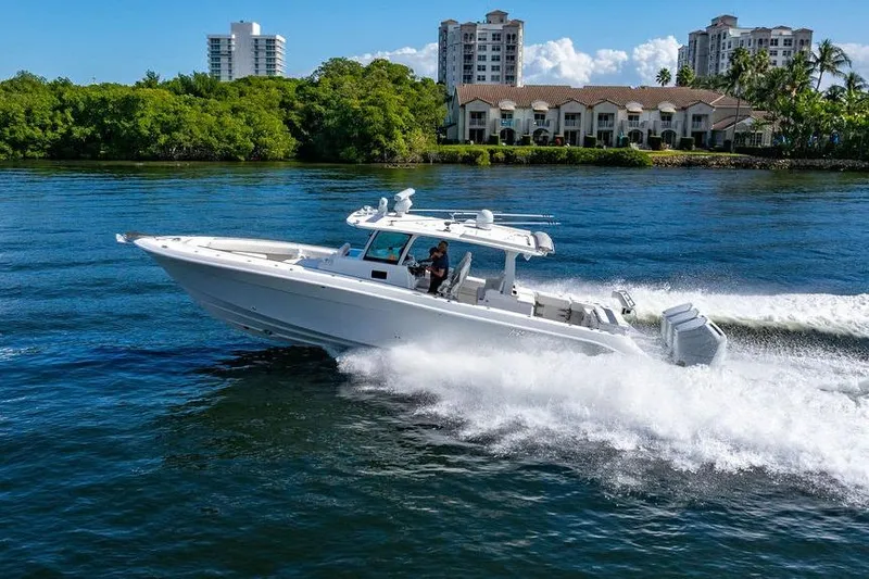  Yacht Photos Pics 2024 HCB 42 Lujo boat cruising on water near luxury waterfront homes.