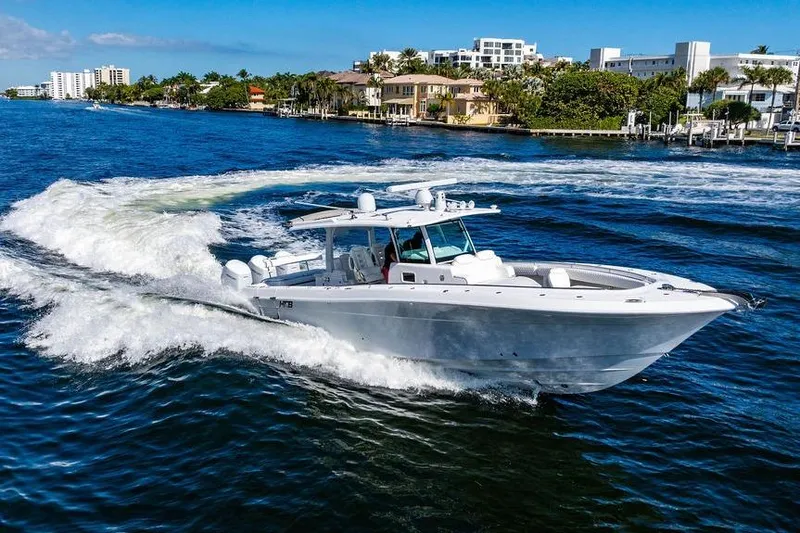  Yacht Photos Pics 2024 HCB 42 Lujo boat cruising on a sunny waterfront with luxury homes.