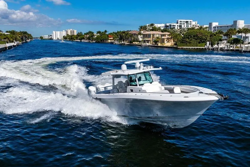  Yacht Photos Pics 2024 HCB 42 Lujo cruising on a scenic waterway with luxury homes in the background.