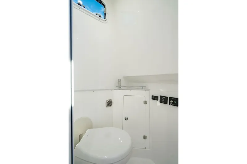  Yacht Photos Pics 2024 HCB 42 Lujo boat interior bathroom with white fixtures and small window.