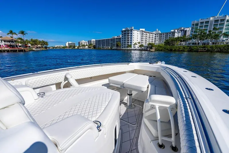  Yacht Photos Pics 2024 HCB 42 Lujo boat with luxurious seating, cruising on a sunny waterfront.