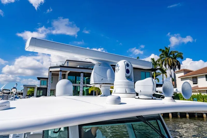  Yacht Photos Pics 2024 HCB 42 Lujo boat with advanced radar and navigation equipment, docked near luxury homes.