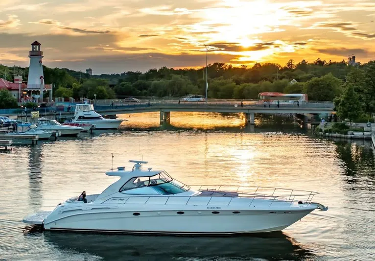  Yacht Photos Pics 2000 Sea Ray 540 Sundancer yacht cruising at sunset near a scenic bridge and lighthouse.