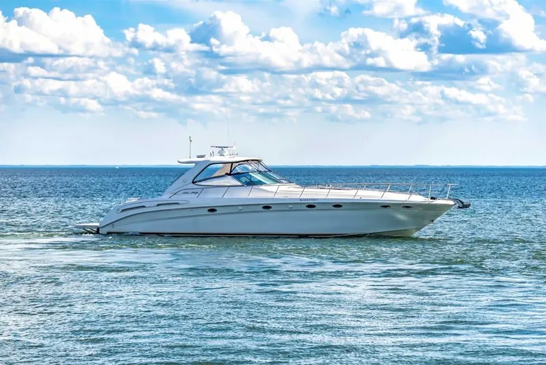  Yacht Photos Pics Sea Ray 540 Sundancer 2000 yacht cruising on open water under a cloudy sky.