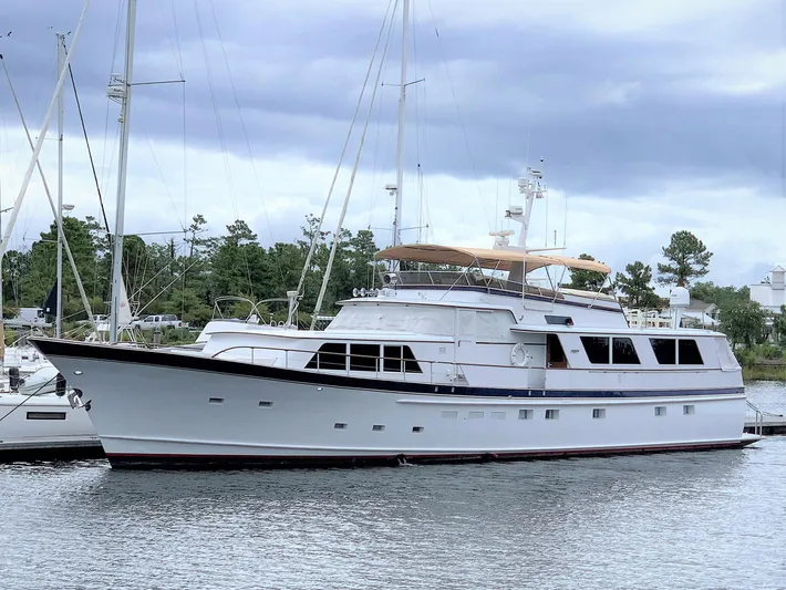 Freedom Yacht Photos Pics 1979 Burger Raised Pilothouse yacht docked in a marina, under a cloudy sky.