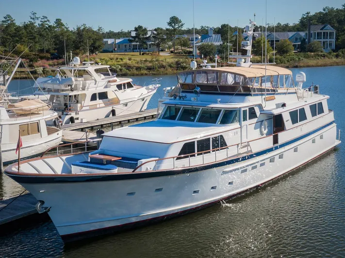 Freedom Yacht Photos Pics 1979 Burger Raised Pilothouse yacht docked in a serene marina setting.